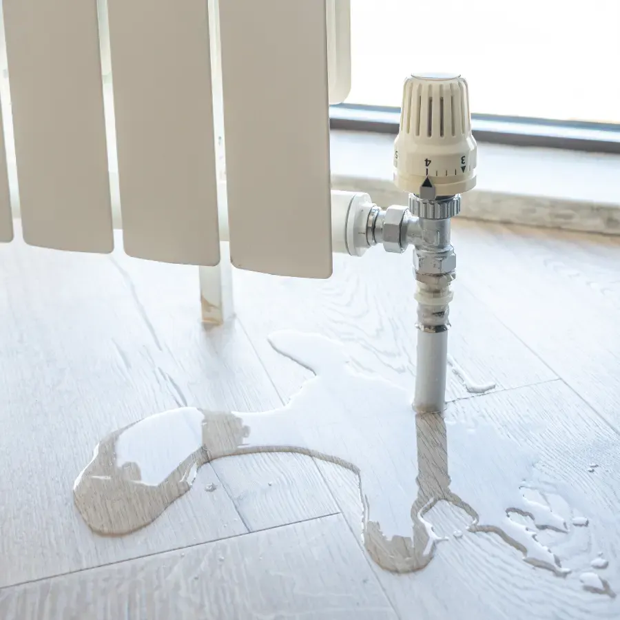 Radiator leaking water across a light floor