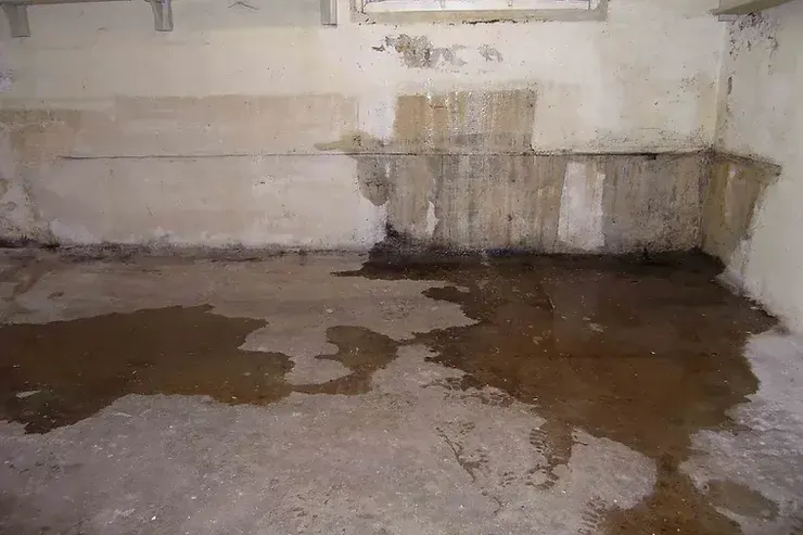 Basement floor and block wall stained by dirty water after a sewer backup